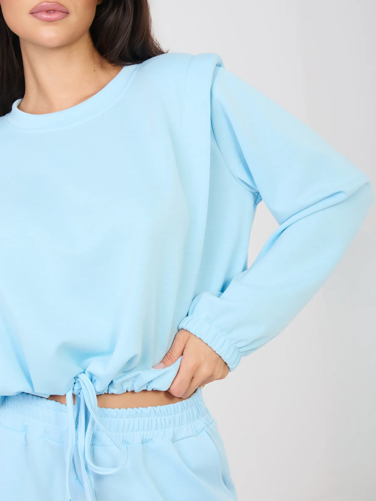 Krótka bluza z wiązaniem i poduszkami na ramionach - zdjęcie 1